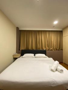 a bedroom with a large white bed with two towels on it at Hotel Ambassador @ Bukit Bintang in Kuala Lumpur