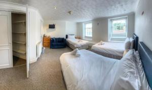 1 dormitorio con 2 camas y espejo en Elmham House - Pilgrim Hotel, en Little Walsingham