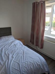 a bedroom with a bed and a window with a curtain at Spacious 2 bed apartment in central Mablethorpe in Birmingham