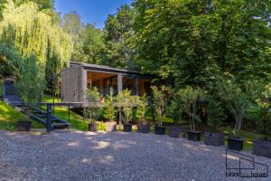 una casita en un jardín con árboles en Blackbox House Noszvaj en Noszvaj