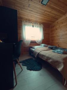 um quarto com uma cama num chalé de madeira em Agroturystyka Rancho Łęg em Kruszyna