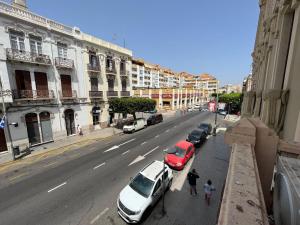 una calle de la ciudad con coches estacionados al costado de la carretera en Triana 3, en Melilla
