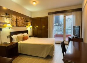 a hotel room with a bed and a television at Hotel HR Plaza Luxor in Buenos Aires