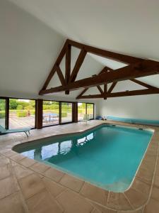 a swimming pool in a house with a large window at La Clé des Champs in Jodoigne