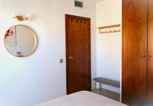 1 dormitorio con espejo y puerta de madera en OLGAPARTMENT, en Miami Platja