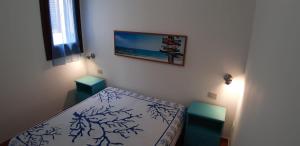 a bedroom with a bed and a picture on the wall at Casa Serena in San Vito lo Capo
