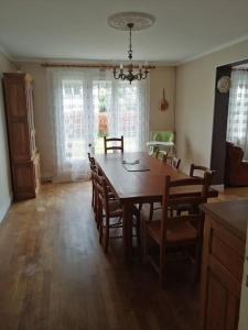 een eetkamer met een houten tafel en stoelen bij Charmant pavillon des années 70 in Sommervieu