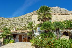 una casa con palmeras frente a una montaña en Villa Piedra, en Puerto Pollensa