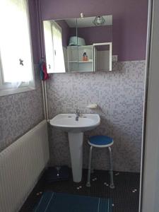 een kleine badkamer met een wastafel en een kruk bij Charmant pavillon des années 70 in Sommervieu