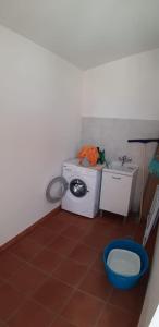 un piccolo bagno con lavatrice e lavandino di Casa Serena a San Vito lo Capo