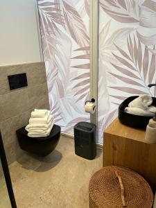 a bathroom with a black toilet and a pink and white wall at Urban Lodges - Studio Apartments am Seerhein in Konstanz