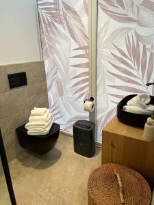 a bathroom with a black toilet and a pink and white wall at Urban Lodges - Studio Apartments am Seerhein in Konstanz +29 photos