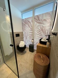 a bathroom with a shower and a sink and a toilet at Urban Lodges - Studio Apartments am Seerhein in Konstanz