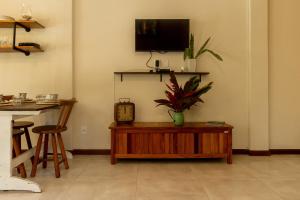 uma sala de estar com um relógio e uma planta sobre uma mesa em Ilhabela Studios em Ilhabela