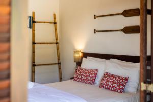 a bedroom with a bed with red pillows at Ilhabela Studios in Ilhabela