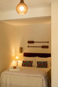 um quarto com uma cama com duas almofadas em Ilhabela Studios em Ilhabela