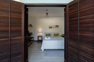 una camera con un letto in una stanza con porte in legno di Ilhabela Studios a Ilhabela Altre 86 foto