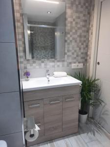 een badkamer met een wastafel en een spiegel bij Apartamento Costa del Sol in Almuñécar