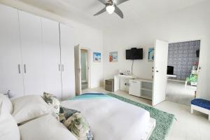 biały pokój z łóżkiem i telewizorem w obiekcie Blue's Guest House - East London Bonza Bay w mieście East London