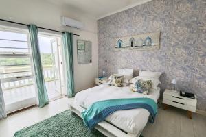 Un dormitorio con una cama grande y una ventana en Blue's Guest House - East London Bonza Bay, en East London
