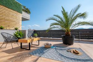 un patio con una mesa y una palmera en fragoseco loft! Elegance & Luxury, en Chalkida