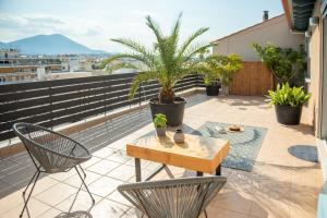 a patio with a table and chairs on a balcony at fragoseco loft! Elegance & Luxury in Chalkida