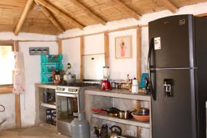 a kitchen with a refrigerator and a stove at Marina Bungalows in Los Órganos