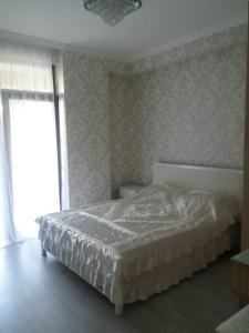 a bedroom with a bed and a window at Apartment in Tbilisi City