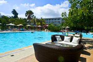 einen Pool mit Stühlen und Menschen in einem Resort in der Unterkunft Sun Palace Hotel Resort & Spa in Kos-Stadt