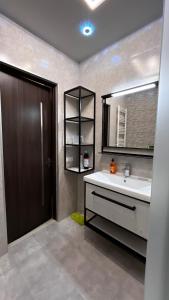 a bathroom with a sink and a mirror at Apartment in Tbilisi City