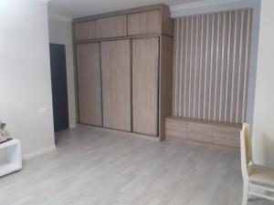 a living room with a large wooden closet at Apartment in Tbilisi City