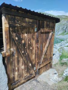 une vieille porte en bois sur le côté d'une montagne dans l'établissement Lake house Draskovici, à Kolašin