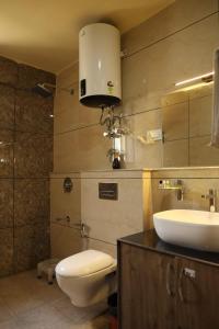 y baño con lavabo, aseo y espejo. en THE JAMAWAR en Srinagar