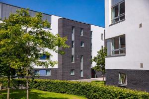 an apartment building with a tree in front of it at Queen Margaret University Residences in Musselburgh