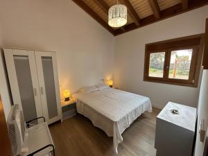 Un dormitorio con una cama blanca y una ventana. en Villas Magnolia y Brezo, en Chiclana de la Frontera 50 fotos más