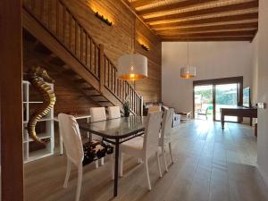 Un comedor con una mesa y sillas blancas. en Villas Magnolia y Brezo, en Chiclana de la Frontera