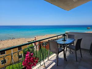 a balcony with a table and chairs and the ocean at Corfu Glyfada Beach Apartments in Glyfada