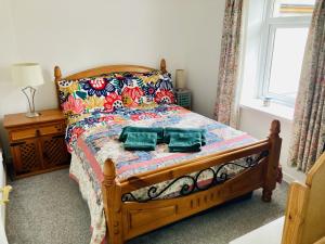 a bedroom with a bed with two towels on it at Spacious cottage, central Ballycastle. in Ballycastle