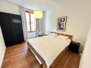 a bedroom with a large bed with a wooden floor at Stay Swiss 1 bedroom apartments in old town in Porrentruy
