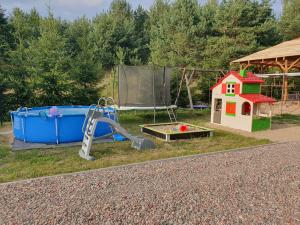 un parque infantil con tobogán y una casa pequeña en Domek na wsi U Wiktora, en Mikołajki