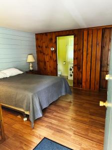 1 dormitorio con 1 cama y suelo de madera en The Reserve on Church, en Saratoga Springs