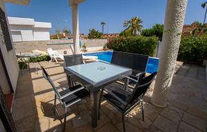 a table and chairs on a patio with a pool at Chalet El Garxal Riumar Pura Natura in Riumar