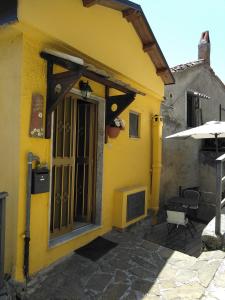 ein gelbes Gebäude mit einer Tür und einer Terrasse in der Unterkunft Casa Vacanze Margherita - Sasso di Castalda in Sasso di Castalda