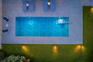 a swimming pool with lights on the side of a building at Sailing Villa Kefalonia in Karavadhos