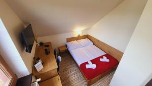 a small room with a bed and a television at Gościniec Konopielka in Zblewo