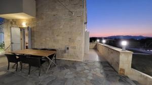 Un comedor con una mesa y sillas en una pared de piedra. en Villa Alex, en Tavronitis