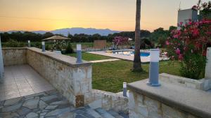 una pared de piedra junto a la piscina en Villa Alex, en Tavronitis