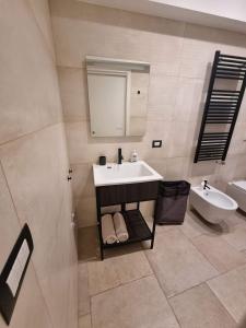 een badkamer met een wastafel, een toilet en een spiegel bij Dimora San Michele in Giovinazzo