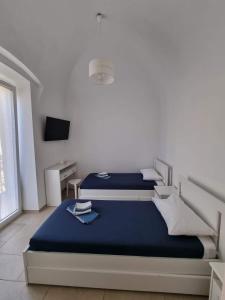 ジョヴィナッツォにあるDimora San Micheleのベッドルーム1室(青いシーツとテレビ付きのベッド2台付)
