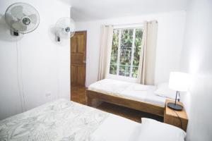 1 dormitorio con 2 camas y ventana en Pura Vibra Hostel, en Fortuna